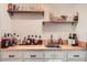 A bar area with light wood countertop, white cabinets, and open shelves displaying an array of glassware and spirits at 1080 Northshore Dr, Roswell, GA 30076