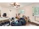 Another angle of playroom with hardwood floors, ceiling fan, windows, and filled with toys and games at 1080 Northshore Dr, Roswell, GA 30076