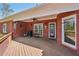 Covered back porch with brick walls, ceiling fan, and wooden deck at 1420 Arblay Pl, Loganville, GA 30052