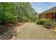 View of the spacious backyard featuring green grass, rock features and mature trees at 1420 Arblay Pl, Loganville, GA 30052