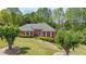Charming single-story brick home featuring a manicured lawn, mature trees, and a welcoming front entrance at 1420 Arblay Pl, Loganville, GA 30052
