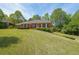 Beautiful red brick home featuring a well-maintained lawn and mature trees at 1420 Arblay Pl, Loganville, GA 30052