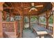 Wooden gazebo interior with dining table, ceiling fan, and swing for relaxing at 1420 Arblay Pl, Loganville, GA 30052