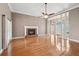 Open-concept living room with a brick fireplace, hardwood floors, and natural light from large windows at 1420 Arblay Pl, Loganville, GA 30052