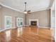 Spacious living room with hardwood floors, fireplace, and a ceiling fan, perfect for relaxation at 1420 Arblay Pl, Loganville, GA 30052