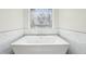 Freestanding tub beneath custom stain glass window in luxurious, modern bathroom at 1420 Arblay Pl, Loganville, GA 30052