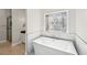 Freestanding tub beneath custom stain glass window in luxurious, modern bathroom with wood look floors at 1420 Arblay Pl, Loganville, GA 30052
