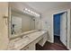 Bathroom featuring a double vanity, granite countertops, and a large mirror with decorative lighting at 2001 Fairbrook Ln, Woodstock, GA 30189