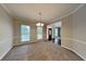 Formal dining room featuring elegant chandelier, carpeting, and natural light from large windows at 2001 Fairbrook Ln, Woodstock, GA 30189