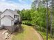 Exterior of the home featuring a raised deck, white siding, well-maintained lawn and wooded lot at 2622 Running River Ct, Lawrenceville, GA 30045