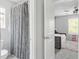 Bright bathroom with a patterned shower curtain and a glimpse into an adjacent bedroom at 2622 Running River Ct, Lawrenceville, GA 30045