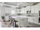 Bright and airy kitchen featuring white cabinetry, gray backsplash, island with seating and modern pendant lighting at 2622 Running River Ct, Lawrenceville, GA 30045