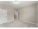 Neutral painted empty room featuring carpet flooring, base molding and access to staircase at 380 Parkside Meadow Dr, Marietta, GA 30064
