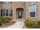 Close-up of the home's entrance with a stylish door, brick surround, and neat landscaping at 380 Parkside Meadow Dr, Marietta, GA 30064