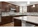 Stylish kitchen featuring dark wood cabinetry, granite countertops, and stainless steel appliances at 380 Parkside Meadow Dr, Marietta, GA 30064
