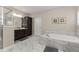 Relaxing main bathroom showcasing a soaking tub with marble surround, dark wood cabinets, and glass shower at 380 Parkside Meadow Dr, Marietta, GA 30064