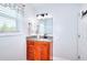 Cozy bathroom with wood cabinets, granite counters, and a bright window at 1621 Dixie Rd, Covington, GA 30014
