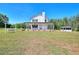 Wide shot of white farmhouse with front porch and large front yard at 1621 Dixie Rd, Covington, GA 30014