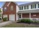 Inviting two-story townhome with a covered front porch, brick accents, and lush landscaping at 210 Cottonwood Creek Cir, Canton, GA 30114