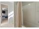 Bathroom with a white tub, a shower head, and doorway to a bedroom with racecar bed at 211 Parc Dr, Canton, GA 30114