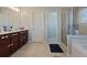 Bathroom featuring dual sinks in dark wood cabinet, framed mirrors, tiled floors, and glass shower door at 211 Parc Dr, Canton, GA 30114