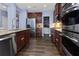 Modern kitchen featuring stainless steel appliances, granite countertops, and dark wood cabinetry at 211 Parc Dr, Canton, GA 30114