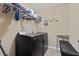 Bright laundry room features side-by-side washer and dryer, hanging rack, and tile flooring at 211 Parc Dr, Canton, GA 30114