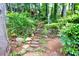 This backyard features a stone pathway surrounded by lush greenery, creating a serene and natural escape at 3910 Meeting St, Duluth, GA 30096