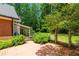 Serene backyard featuring a covered porch, brick patio, and lush greenery, perfect for outdoor relaxation at 4930 Forestglade Ct, Tucker, GA 30087