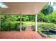 Picturesque backyard with brick patio, pond, mature landscaping, and a small garden shed at 4930 Forestglade Ct, Tucker, GA 30087