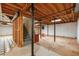 Unfinished basement with concrete floor and exposed wood ceiling beams and support posts, offering potential for customization at 4930 Forestglade Ct, Tucker, GA 30087