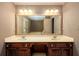 Bathroom with double vanity with wood cabinets, large mirror, and bright lighting at 4930 Forestglade Ct, Tucker, GA 30087