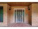 Elegant front door with decorative glass panels and classic sconces, set in a brick facade at 4930 Forestglade Ct, Tucker, GA 30087