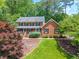 Beautiful two-story brick home with a well-manicured lawn, mature trees, and a welcoming front porch at 4930 Forestglade Ct, Tucker, GA 30087