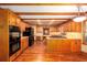 Large open kitchen featuring wood cabinets, beams, and stainless steel appliances at 4930 Forestglade Ct, Tucker, GA 30087