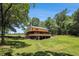Exterior view of home with large, grassy backyard and mature trees at 1795 Hutcheson Ferry Rd, Whitesburg, GA 30185