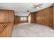 Large bonus room area with wood paneling, carpet and ceiling fans at 1795 Hutcheson Ferry Rd, Whitesburg, GA 30185