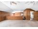 Spacious bonus room with wood paneling, neutral carpet, and ceiling fans at 1795 Hutcheson Ferry Rd, Whitesburg, GA 30185