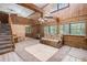 Cozy living room with high ceilings, rustic wood paneling, and staircase at 1795 Hutcheson Ferry Rd, Whitesburg, GA 30185