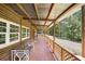 Spacious covered porch with outdoor seating and rustic log siding at 1795 Hutcheson Ferry Rd, Whitesburg, GA 30185