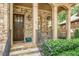 Elegant home entryway with stone accents, a dark wood door, and wrought iron railings at 2672 Brickell Square, Atlanta, GA 30341