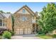Charming stone-front home featuring an attached two-car garage and inviting curb appeal at 2672 Brickell Square, Atlanta, GA 30341
