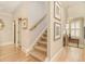 Hallway with hardwood floors and staircase with carpeted steps, decorated with framed pictures on the walls at 2672 Brickell Square, Atlanta, GA 30341