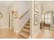 Hallway with hardwood floors, staircase, and neutral-toned walls decorated with artwork at 2672 Brickell Square, Atlanta, GA 30341