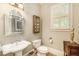 Cozy powder room featuring a pedestal sink, decorative mirror, and natural light at 2672 Brickell Square, Atlanta, GA 30341