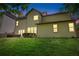 Green backyard with a patio, table and chairs at twilight at 3220 Goldmist Dr, Buford, GA 30519