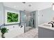Updated bathroom with a soaking tub, glass shower, and double vanity with stone countertops at 3220 Goldmist Dr, Buford, GA 30519