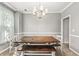 Formal dining room with a rustic wooden table set, neutral paint, and a traditional chandelier at 3220 Goldmist Dr, Buford, GA 30519