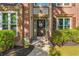A welcoming front entrance, featuring brick accents and a decorative wreath on a dark-colored door at 3220 Goldmist Dr, Buford, GA 30519