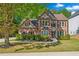 Charming two-story brick home featuring a manicured lawn and mature trees creating curb appeal at 3220 Goldmist Dr, Buford, GA 30519